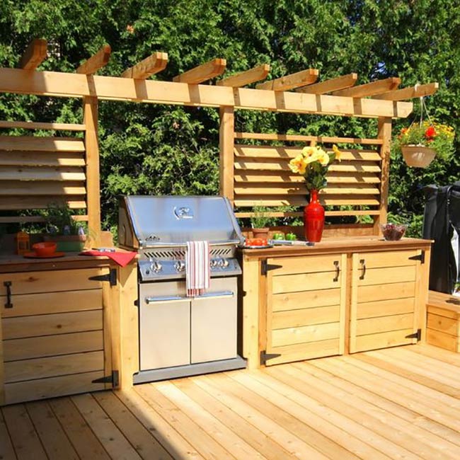 The warm wood pergola and cabinets create a beautiful, cohesive look for this backyard spot. Slatted privacy screens behind the grill offer a nice secluded feeling while you cook. It feels like a sunny vacation spot.