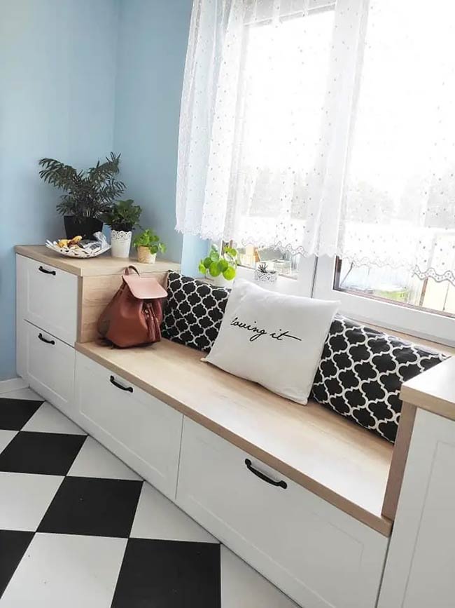 The black and white checkered floor looks great with this clean white storage unit. Large drawers provide plenty of space to hide things away and keep the room tidy. The light wood top adds a warm touch and offers a nice place to sit or display plants.