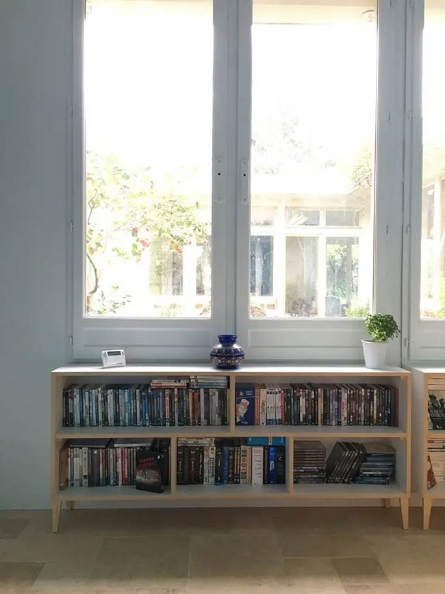 This low cabinet sits on thin wooden legs for a light and airy look. It is packed with movies and books but still lets light flood in from the big window. It’s a simple piece of modern furniture that adds useful storage without being bulky.