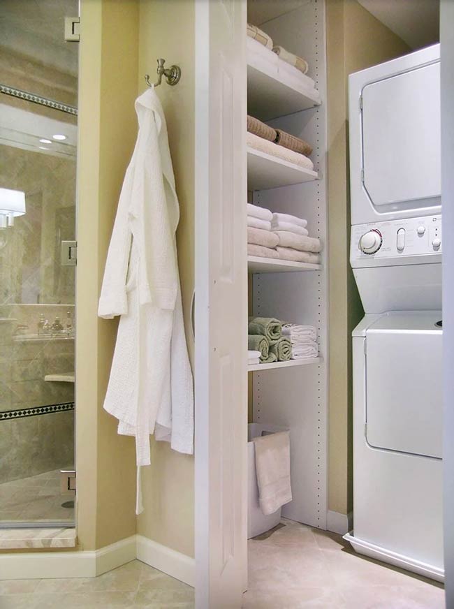 Stackable appliances are cleverly tucked behind a linen closet in this master bathroom. Narrow shelving and plastic hampers keep laundry sorted and accessible. This design maximizes a tight space and adds convenience without compromising the bathroom’s aesthetics.